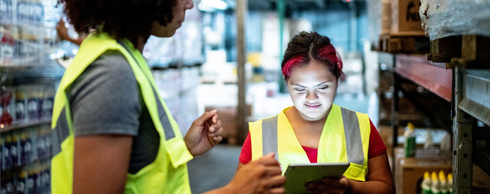 Workers collaborating in a warehouse using a tablet